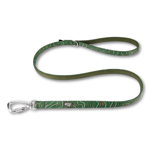 Twiggy Tags Apex Dog Lead in Nomad pattern which is a dark green with white contour lines and small orange trig points. The lead has a soft, neoprene backing 